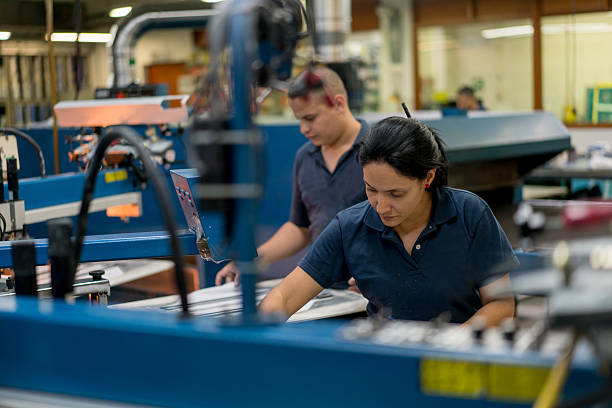workers of a textile mill working on the machines and the factory look and background